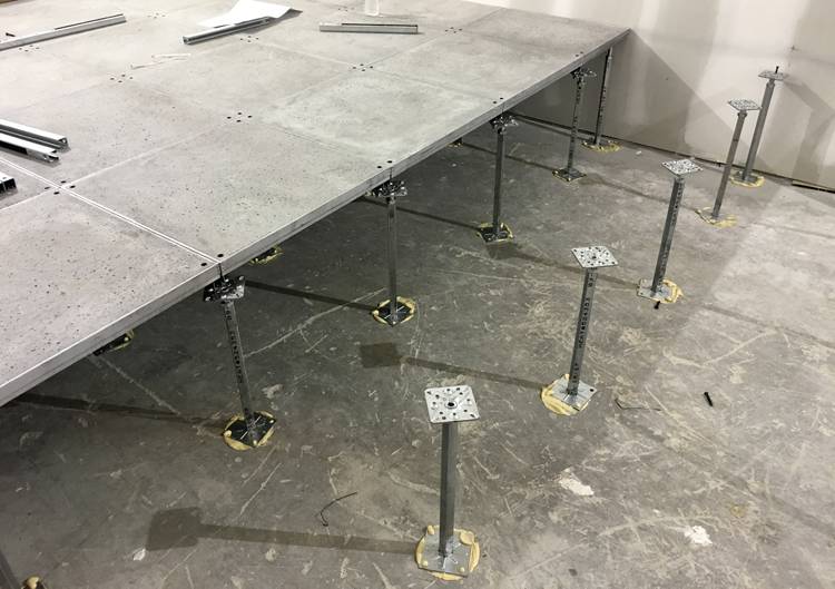 Photo of raised access floor installation showing tiles with integrated stringers and pedestals