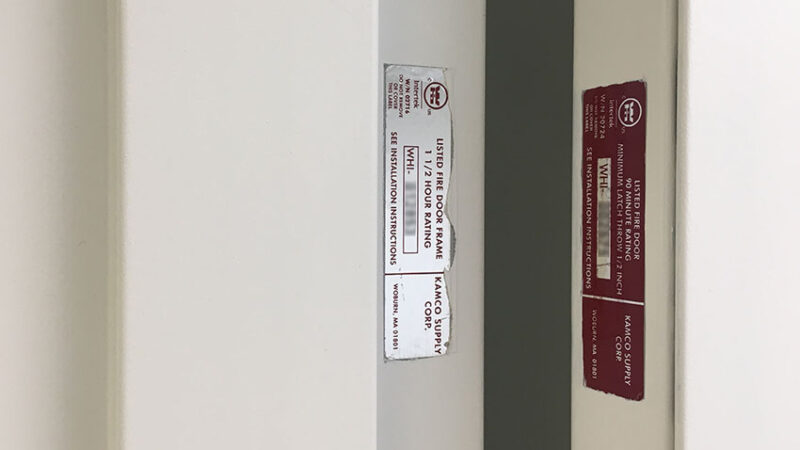 Photo of an Intertek door label mounted to door frame at left and mounted to door at right