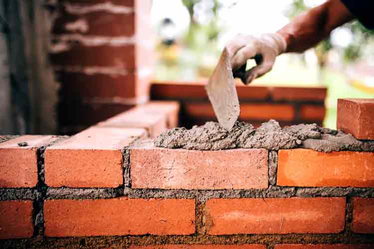 Photo of a mason installing mortar