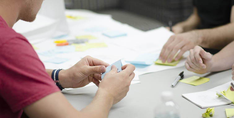 Photo of a project planning meeting with post-it notes