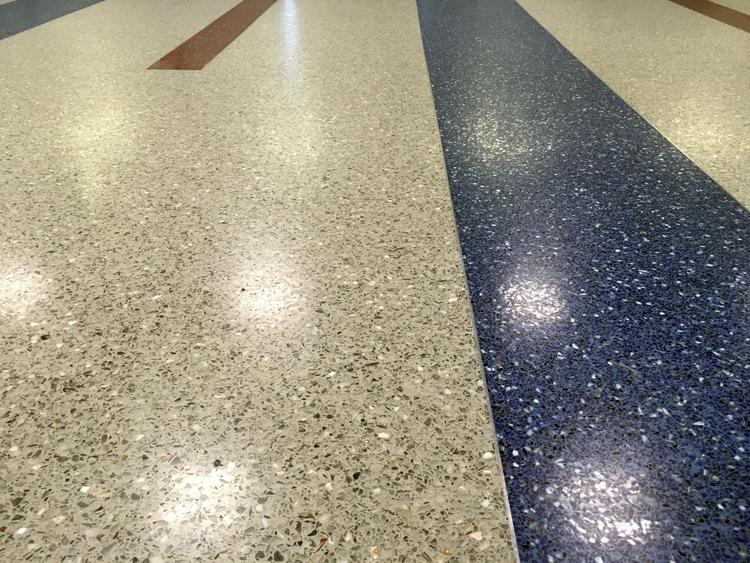 Closeup photo of a terrazzo floor. A zinc strip separates the different colors.