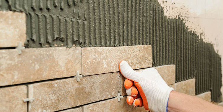 Photo of wall tile being set into a mortar bed